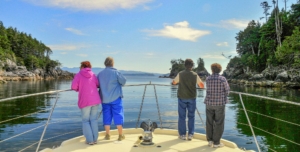 4 ladies on bow of boat, looking at view of islands ahead of boat